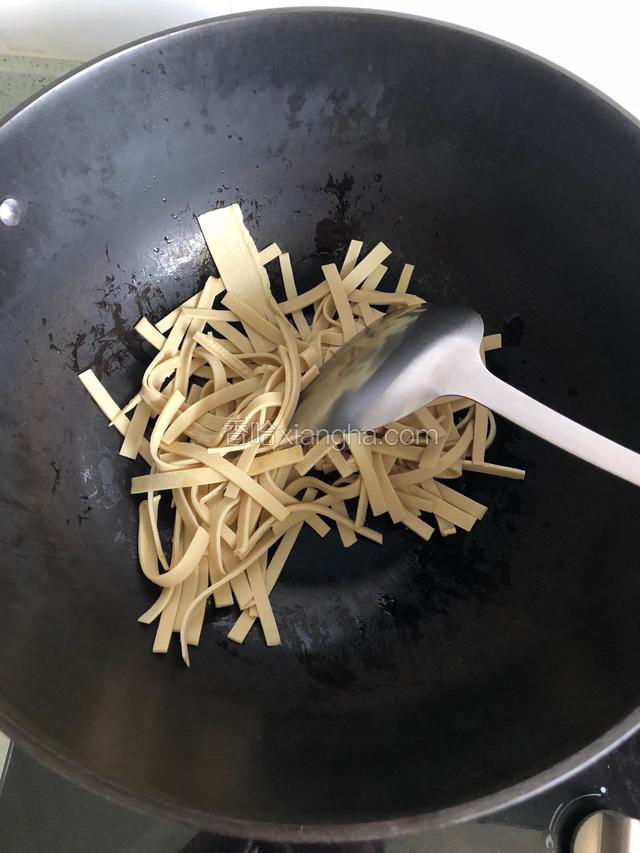 锅中倒入油，油热后放入豆腐皮翻炒（油可以稍微多一点，这样豆腐皮比较好吃）。