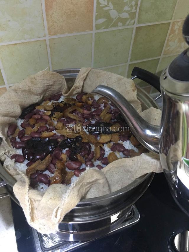 继续大火蒸30-40分钟，点第二次开水，然后转中小火蒸四个小时。此时蒸布上水气也少了，可以点第三次开水了，为了不让上层的米发干。然后转小火继续蒸两个小时。整个蒸的过程中注意给锅里添凉水，防止干烧！
