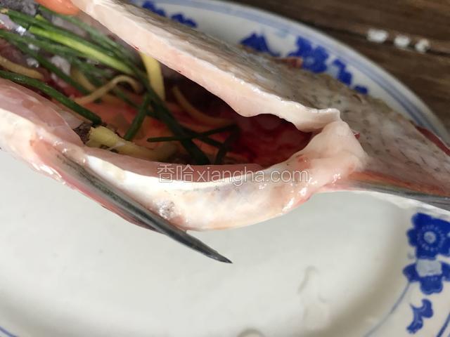 把姜丝和葱段塞入一部分到鱼肚里