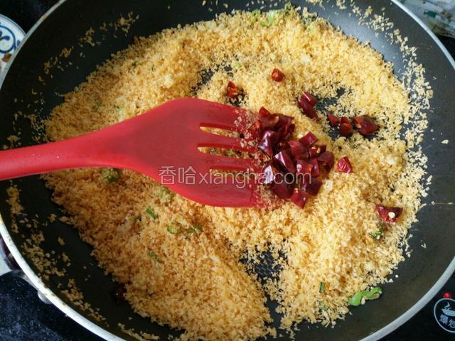 接着把面包糠和干辣椒放进去，继续炒