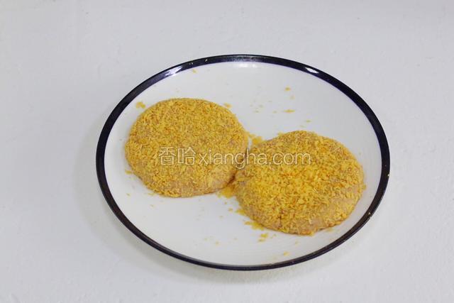 给压好的肉饼裹上面包糠。