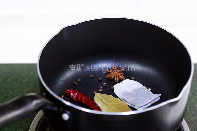 在锅内加入干辣椒、花椒、红茶包、八角和香叶。