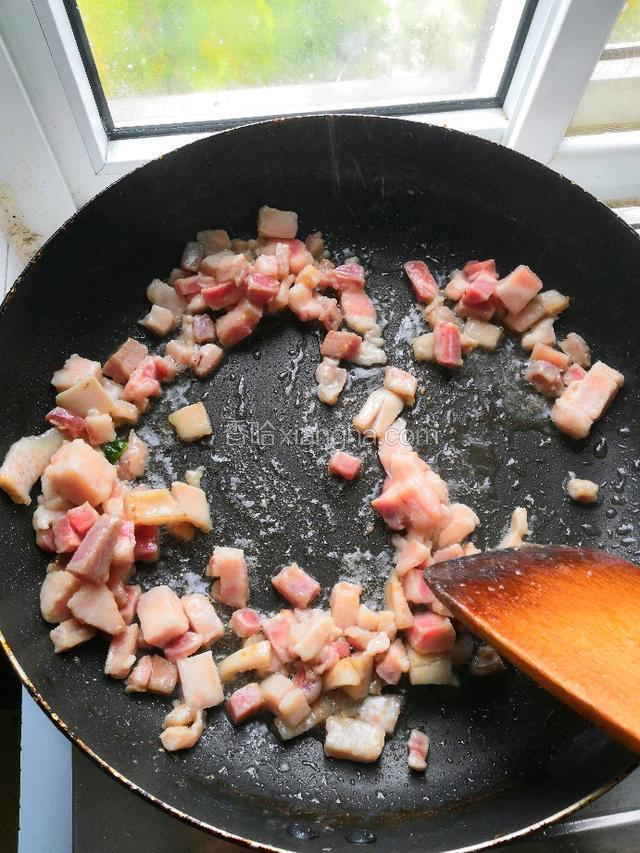 锅中烧油，放入腌制好的肉丁炒至变白。