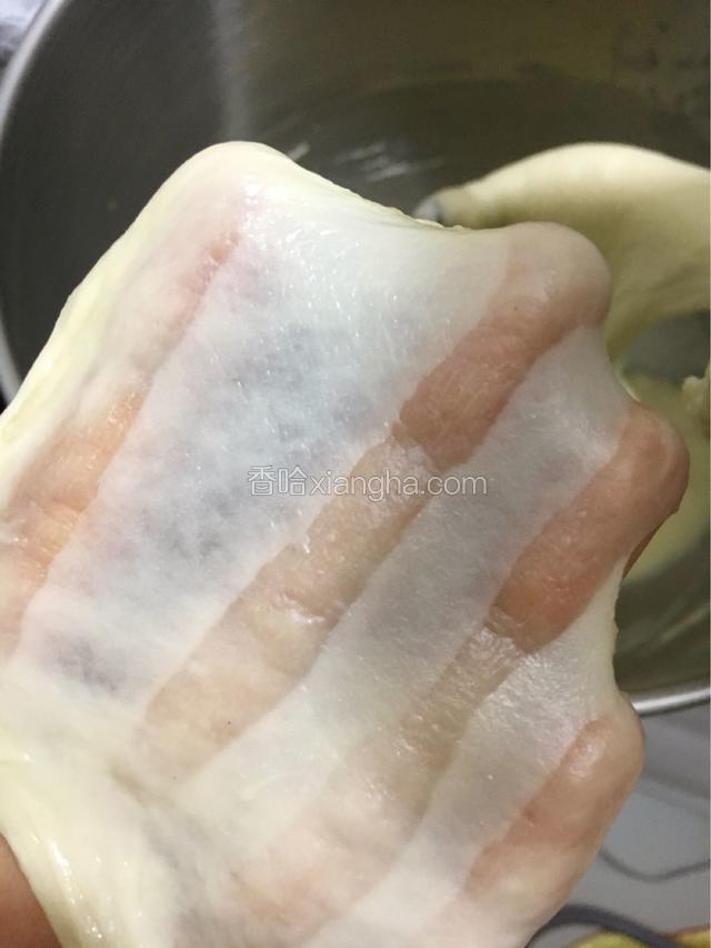 启动厨师机先低速转中速打至面团略滑，加入软化的黄油，再打至面团能拉出薄膜的状态。