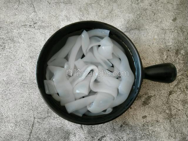大拉皮放入碗中 倒点清水 黏在一起的拉皮 遇水就分开了。