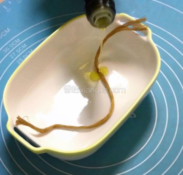 棉线剪成30厘米的长度，滴上食用油抹匀。
