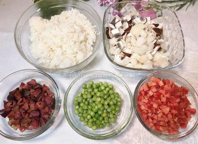 腊肠、胡萝卜、牛肝菌切丁，豌豆洗净，米饭用筷子刨松（若是进了冰箱的剩饭可以放微波炉加热1分钟）。