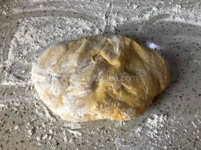 案板上撒少许玉米淀粉，把面团放上去，用擀面杖擀开。