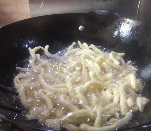 下入一半的面条炸至金黄，大约20秒左右就可以捞出沥干油。