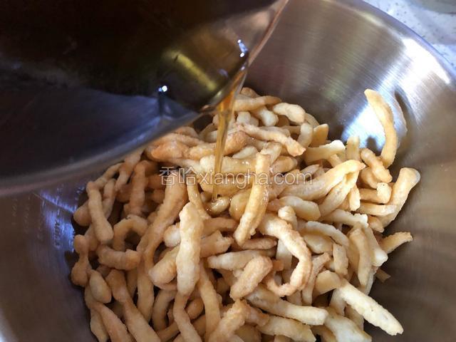 把面条放入一个大盆中，倒入熬好的糖浆。