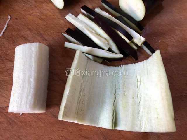 将茄子洗净，切成段后，沿着茄子皮切一圈下来，中间的白芯不要。再切成细条。