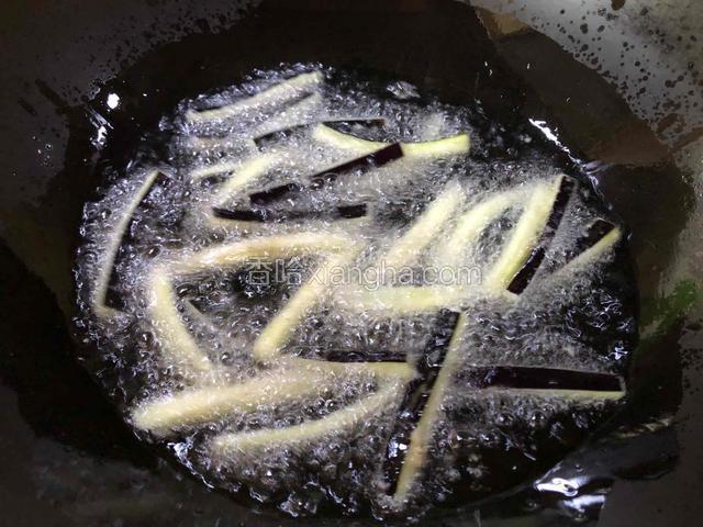 分次下入茄条用中火炸至金黄。（一次别下入太多茄条，太多了容易粘连）