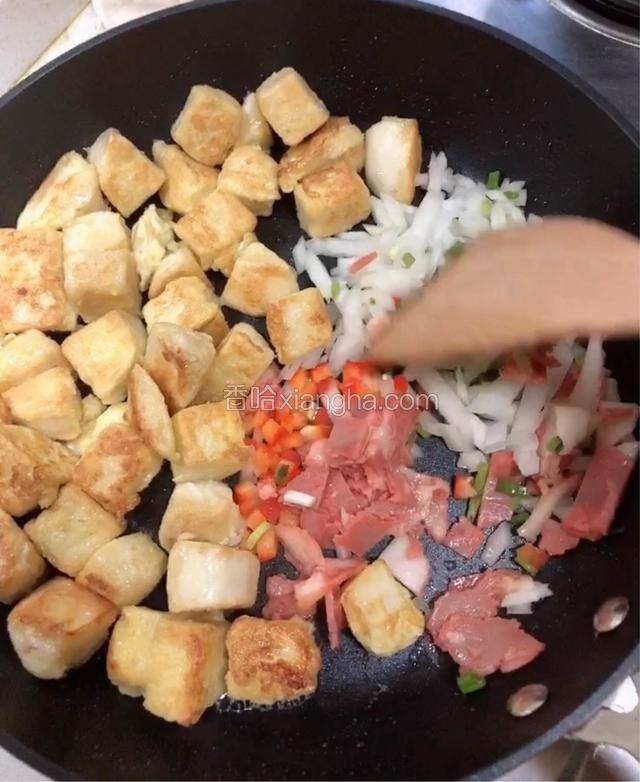 锅中一半位置倒入培根、洋葱、红椒、小葱翻炒。