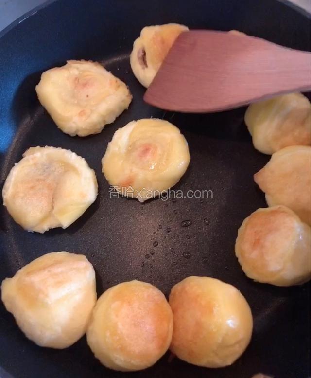 盖上锅盖焖几分钟，翻面煎至两面焦黄。用锅铲子按扁豆包。