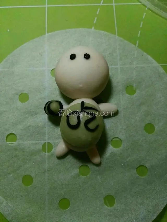 用适量黑色搓揉长条，做吃字粘上，然后用深绿色和黑色做西瓜粘右侧胳膊上。