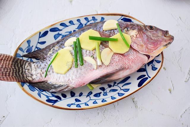 然后在鱼上放上另一半葱姜蒜
