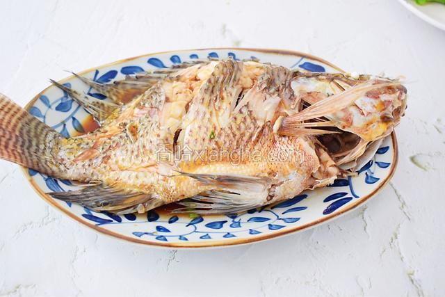 取出夹掉葱姜蒜，倒掉蒸鱼里的汤汁，就是这一步不可省略，一定要倒掉，因为鱼的腥味都在这汤汁里。然后再淋入蒸鱼鼓油