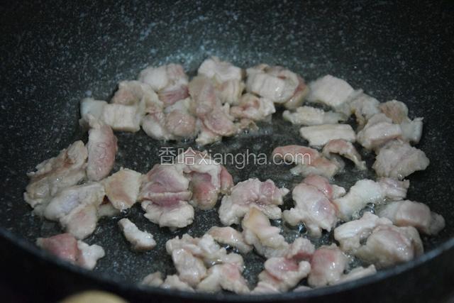 热锅凉油，倒入腌好的猪肉煎至两面微黄