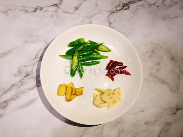在焯白蘑菇的时候，可以把姜二、蒜切片，二荆条、小米辣斜刀切段放入盘中备用。
