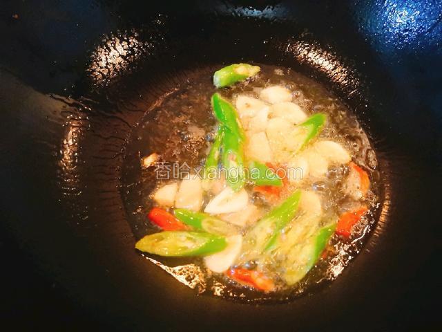 锅中放入菜籽油，烧熟后倒入姜、蒜、二荆条、小米辣爆炒。