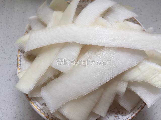 然后用削皮刀将萝卜皮削成一厘米左右的宽度。