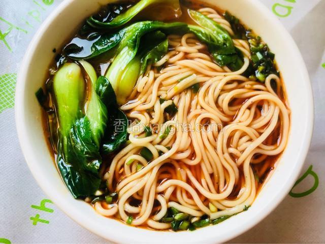 然后舀少许面汤在料碗里，再捞面条