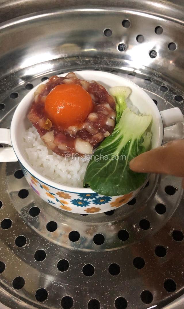 饭熟放上蛋黄腊肉饼，青菜，大火蒸10分钟。