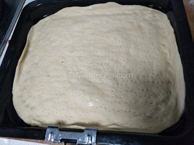 披萨盘先刷层玉米油，放入披萨饼，用叉子戳孔