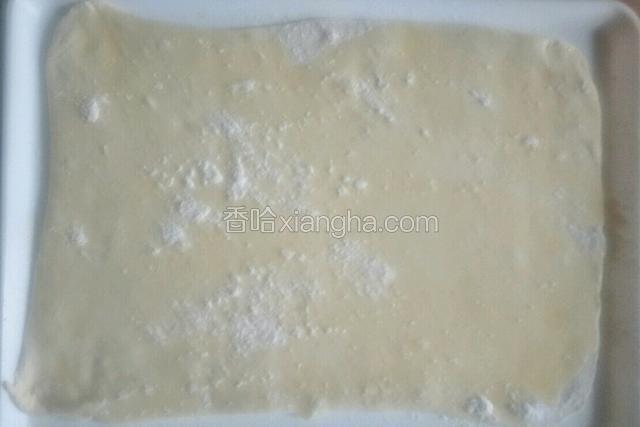 把面团擀成长方形薄饼，
刷一层玉米油撒适量干面粉