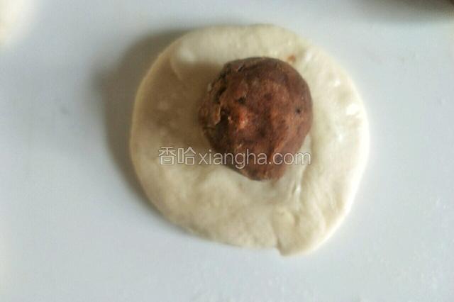 取一个面团按扁，包入豆沙馅