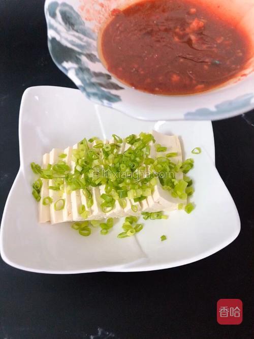 将酱汁倒在豆腐片儿上。
