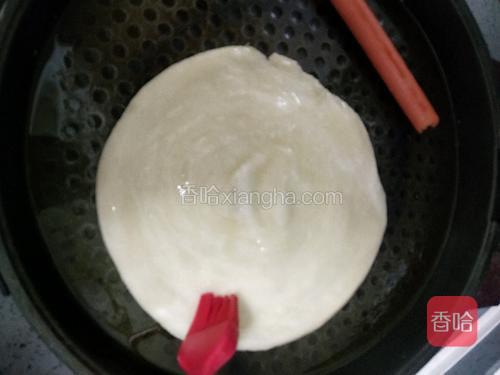 电饼铛刷油，放入生胚，表面也刷一层油。煎2分钟翻面。顺便把火腿肠也煎热。