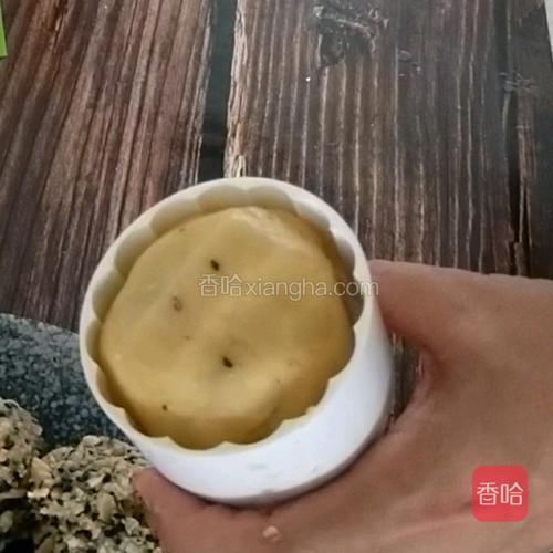 取月饼的模具，将团好的饼坯装入模具里。