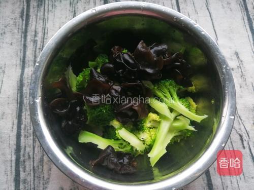 将西兰花和木耳捞出放入容器中，浇入做好的调料，搅拌均匀即可。