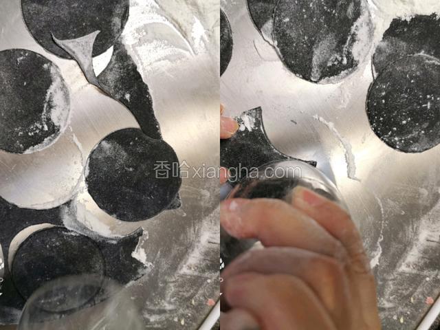 黑色面团擀成饺子皮厚度，用圆口玻璃杯压出圆形，再压出一个扇形。