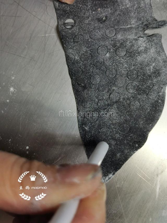 用粗吸管在黑色饼皮上压出小圆圈做眼睛。