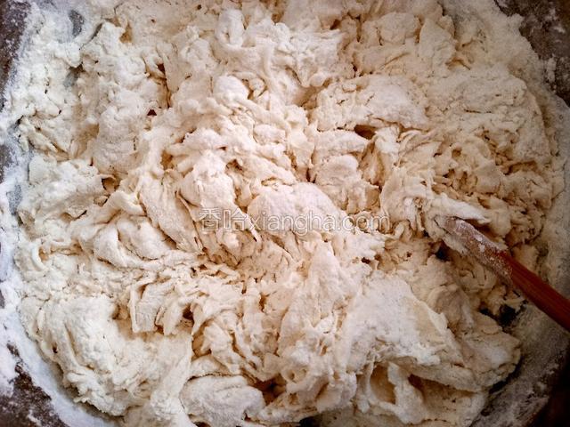 分次加入适量温水，用筷子搅拌成棉絮状，至无干粉。