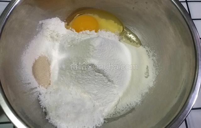 盆里筛入高粉，打入鸡蛋全蛋一个，酵母粉和盐对角放，白糖放入。