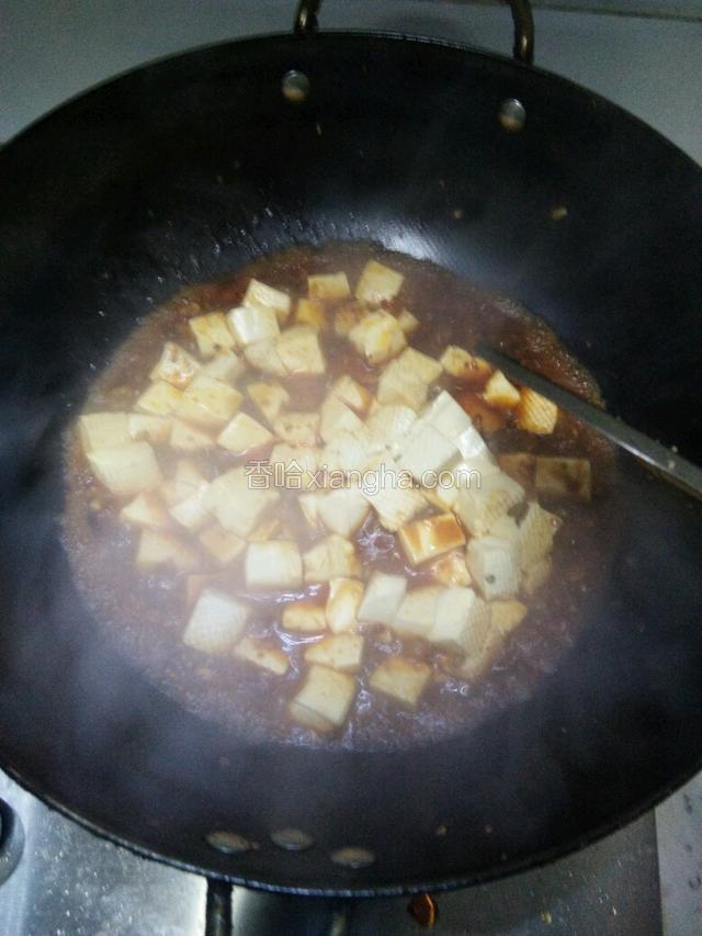 下入豆腐，调料：盐，白糖，生抽老抽，鸡精，轻轻推动，煮一分钟，让豆腐完全入味。