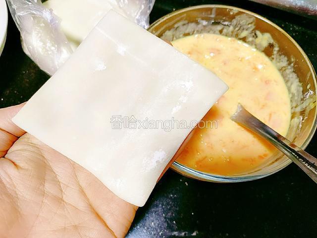胡萝卜鸡蛋糊搅拌好后，拿出抄手皮，开始包抄手三角形