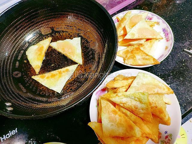 用同样的方法，将所有的三角形抄手制作完成，再一个一个地夹入盘中，晾一晾