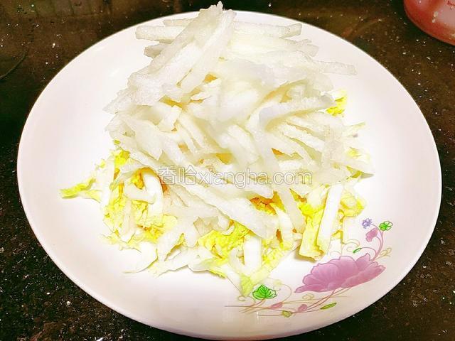 接着把梨丝用筷子夹入娃娃菜心上方