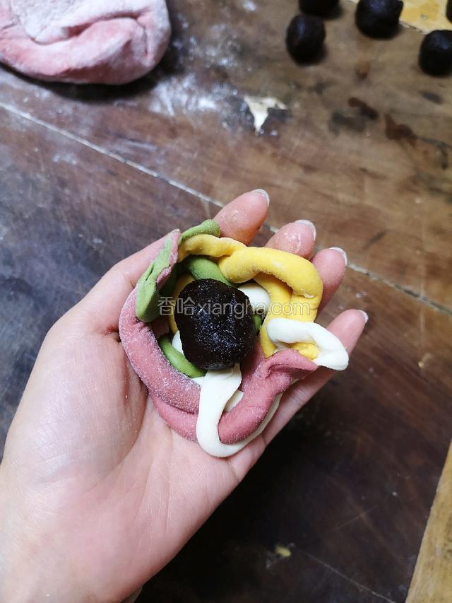 将盘好的面团中间放上豆沙馅，包起来。