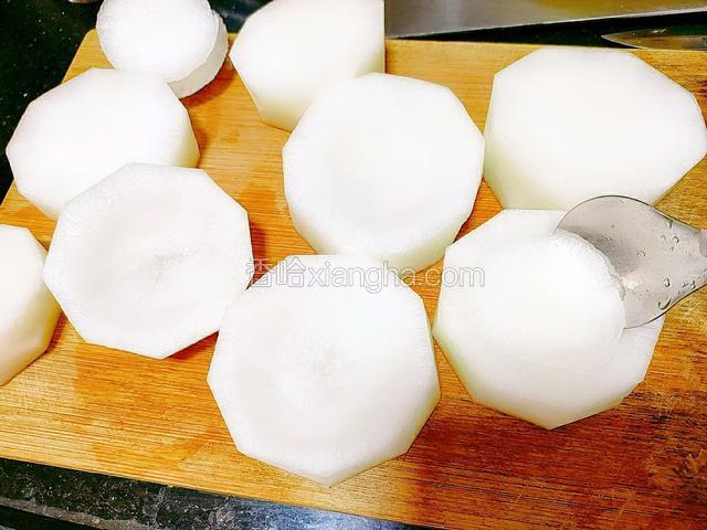 用勺子在白萝卜上方旋转，挖出一个半圆形