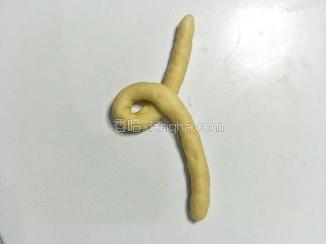 把两头的面团交叉，如图所示。一头略长。