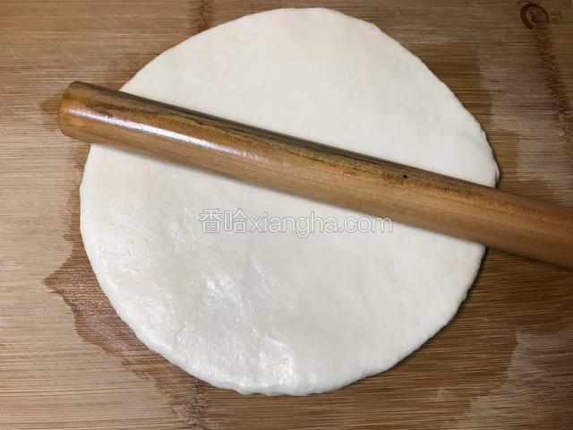 将案板和擀面杖抹少许食用油，再将静置好的面团擀成圆形。