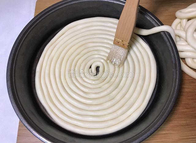 取一个平底的容器，刷一层食用油，将搓好的面条从中间开始盘起，每盘好一层表面再刷一层油。