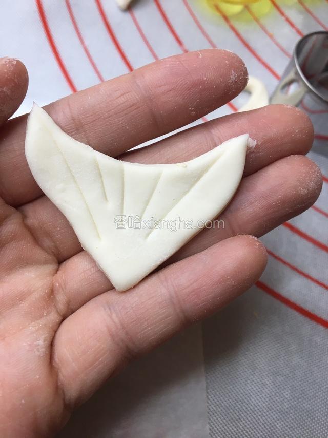 取一块白色的面团压出三角形做它的胡子