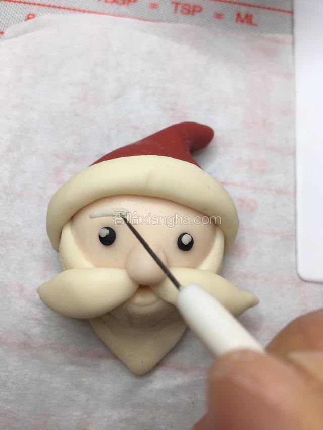 切两根白色的面条做它的眉毛，眉毛可以粗一点