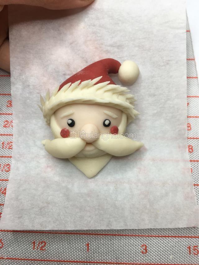 再用剪刀，围着它的帽子边剪出毛绒的感觉就可以。最后取两块红色的面团做它的小腮红！一款圣诞老人的造型就完成啦